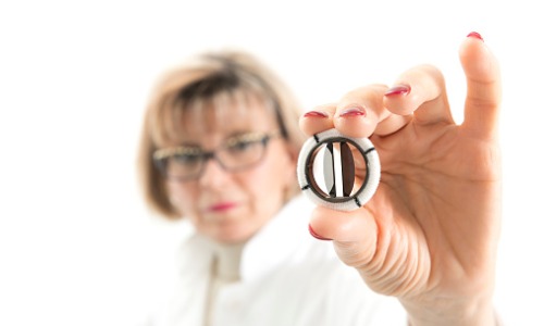 experienced-female-doctor-is-holding-artificial-mechanic-heart-valve-picture-id698595258