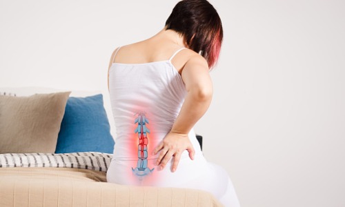pain-in-the-spine-woman-with-backache-at-home-injury-in-the-lower-picture-id1057849956